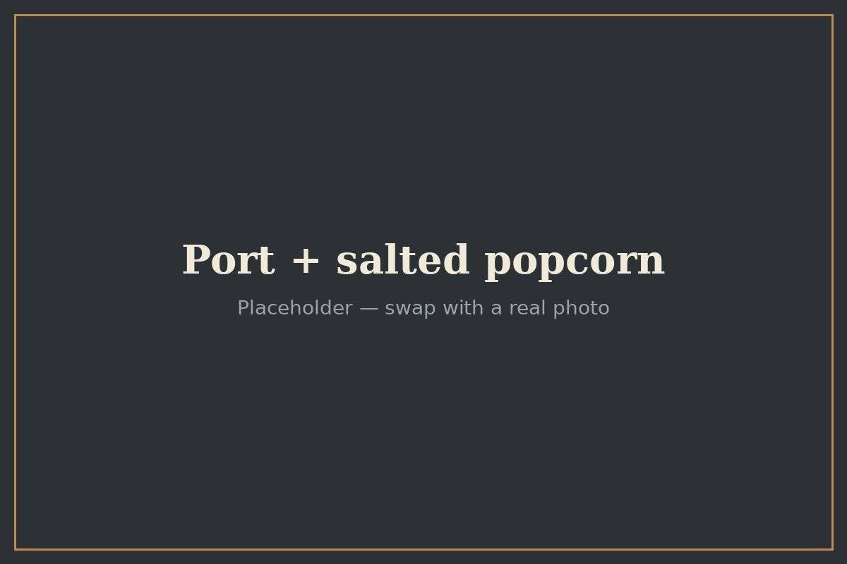 A glass of Port served with a bowl of salted popcorn